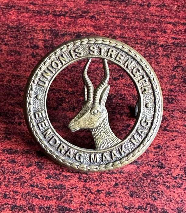 SA GENERAL SERVICES CORPS CAP BADGE (BRASS) 2 LUGS-WORN WW2