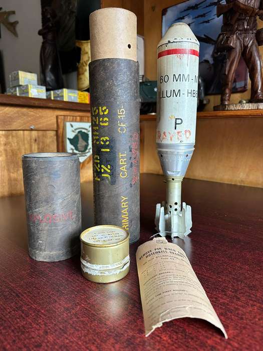 60 MM illuminating bomb type 62 in complete condition ,with range table and holder. Inert