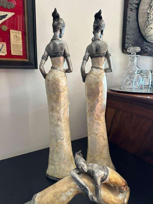 Three decorative composite moulded figurines,decorated with applied mother of pearl. Height of talle