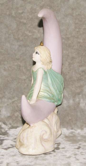 Ceramic fairy sitting on a moon statue