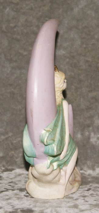Ceramic fairy sitting on a moon statue