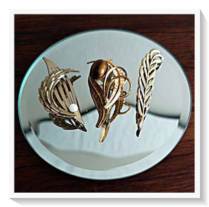 A Vintage Trio of Gold Plant Like Motif Brooches including an Oval Tigers Eye
