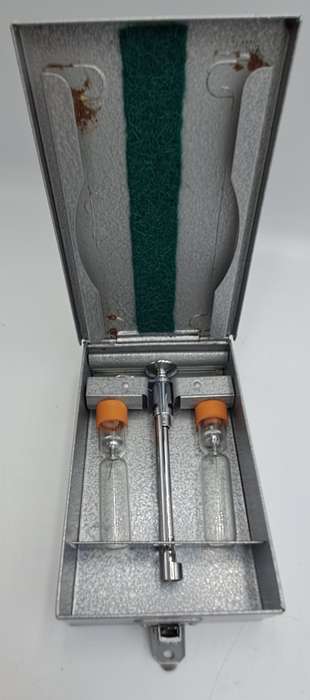 Boots viule syringe in a metal case with two glass containers with needles inside.