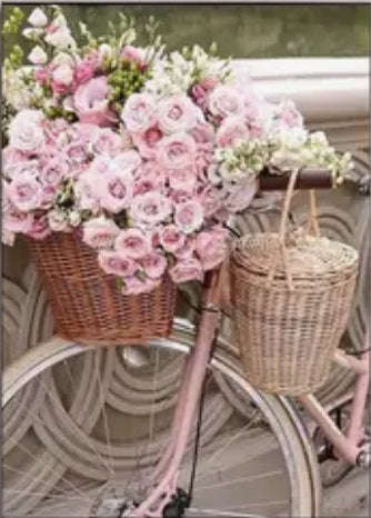 Pink bicycle with flowers in basket