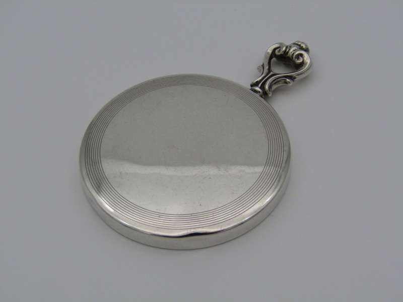 A sterling silver hand mirror by Cartier. Circa 1920s.