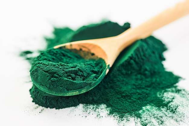 Spirulina powder in a wooden spoon Premium Photo