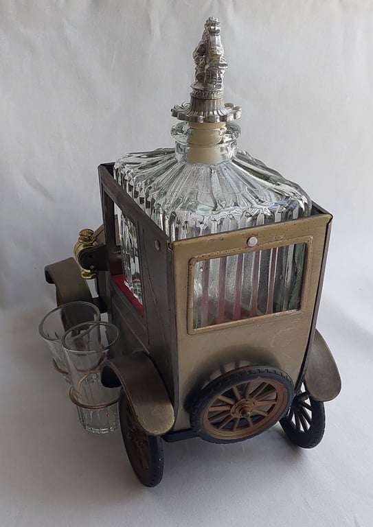 A Vintage 1970's, (1918 Model T Ford - Whisky Decanter) with a working musical box & shot glasses