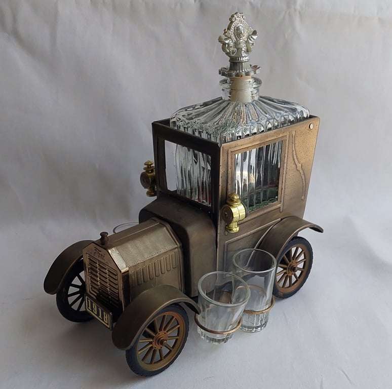 A Vintage 1970's, (1918 Model T Ford - Whisky Decanter) with a working musical box & shot glasses