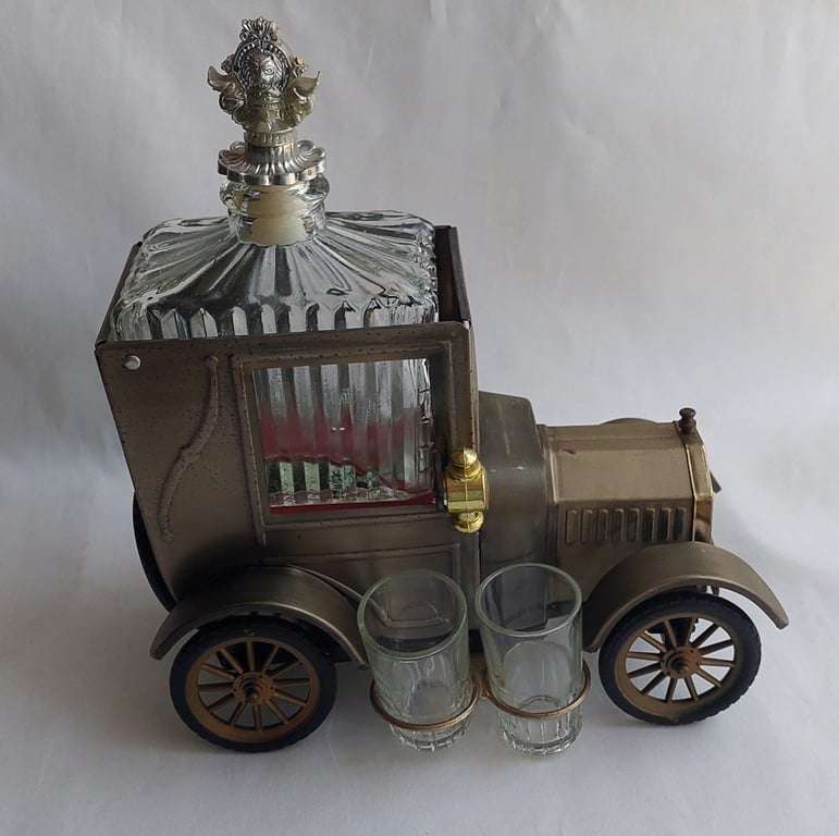 A Vintage 1970's, (1918 Model T Ford - Whisky Decanter) with a working musical box & shot glasses