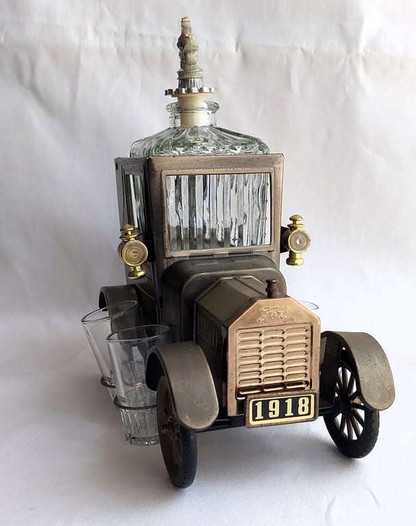 A Vintage 1970's, (1918 Model T Ford - Whisky Decanter) with a working musical box & shot glasses