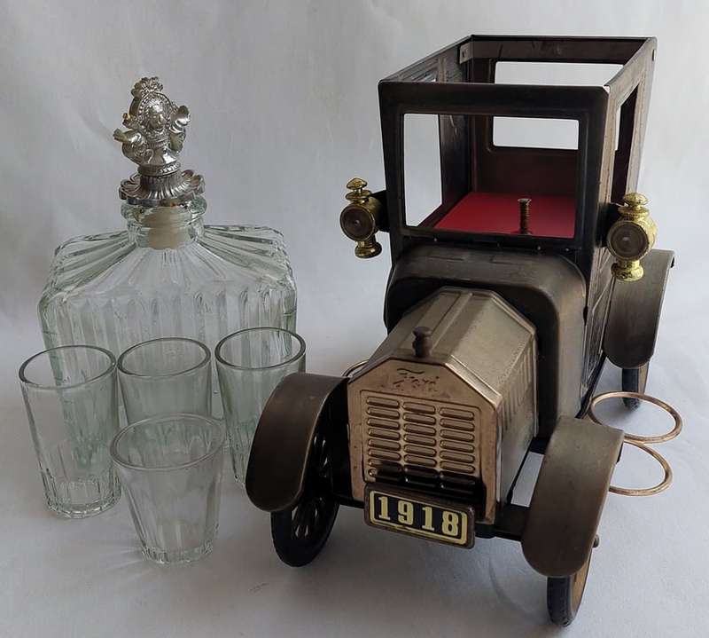 A Vintage 1970's, (1918 Model T Ford - Whisky Decanter) with a working musical box & shot glasses