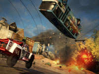 A suped up truck racing towards an exploding bus launched into the sky in Motorstorm Apocalypse
