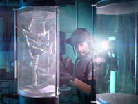 A marine examining a confined Facehugger variety of alien up close in Aliens: Colonial Marines