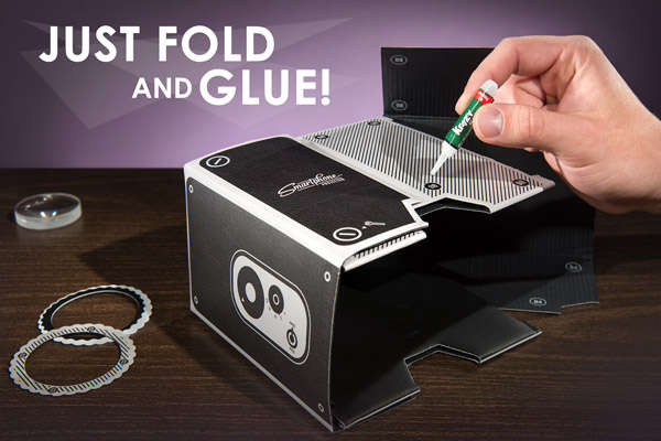 A hand glues a smartphone projector together.