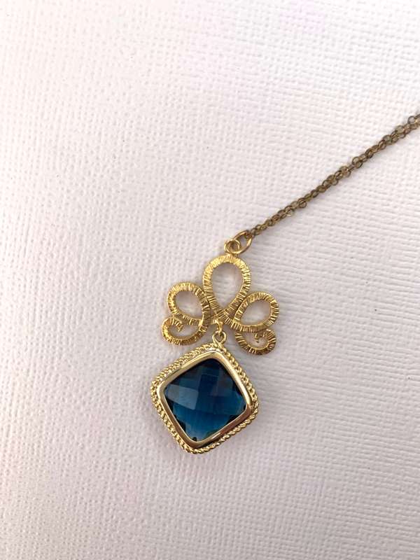 Pendant and Chain - Gold Colour Square Pendant Hung at angle from decorative pattern on Gold Colo...