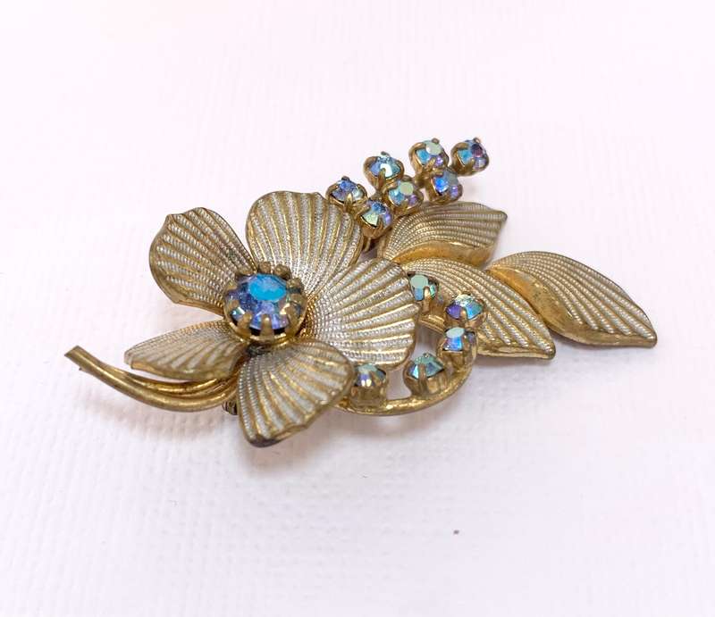 Brooch - Shiny blueish Stones With Fluted Flowers. Gold Colour #ML1037 R195.00 | Dimensions: 54mm...