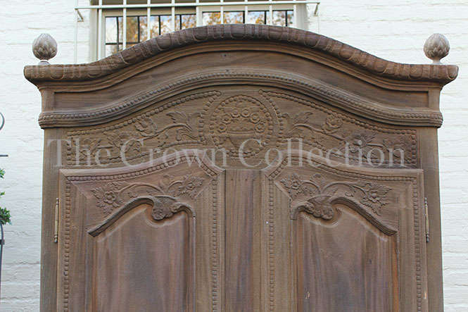 A 20th Century French Style Armoire in a  Carved Wood and in a Natural Wood Finish