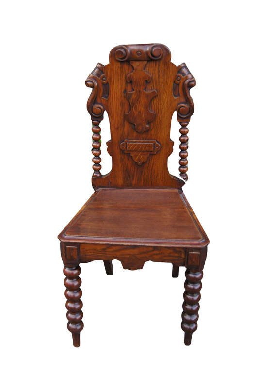 A Late Vicrian Oak Hall chair with with burbon stile on scrolled ear on back rest and a scrolled ...
