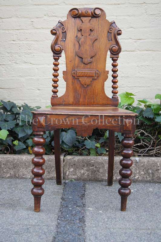 A Late Vicrian Oak Hall chair with with burbon stile on scrolled ear on back rest and a scrolled ...