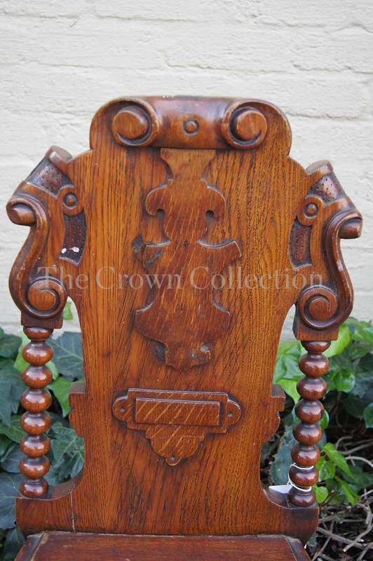A Late Vicrian Oak Hall chair with with burbon stile on scrolled ear on back rest and a scrolled ...