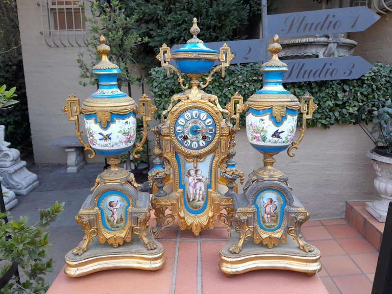 A 19th Century French  Gilt Metal And Porcelain Clock Garniture Set On Original Giltwood Bases A...