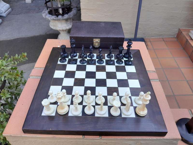 A 20th Century Hand Carved Ebony And Ivory Chess Set With Board And Leather Case