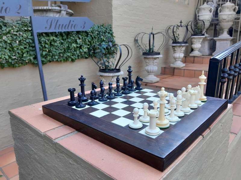 A 20th Century Hand Carved Ebony And Ivory Chess Set With Board And Leather Case
