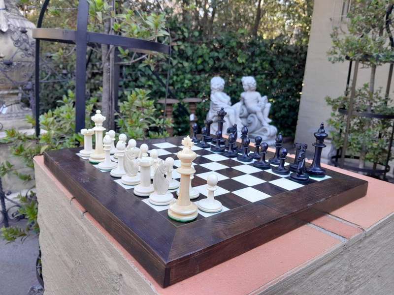 A 20th Century Hand Carved Ebony And Ivory Chess Set With Board And Leather Case