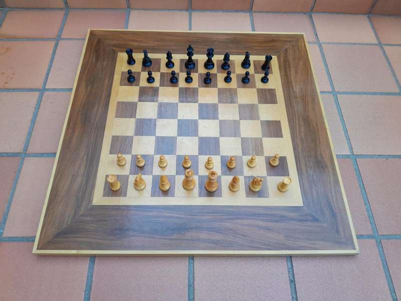 A Wooden Chess Set Comprising Chess Pieces And A Chess Board