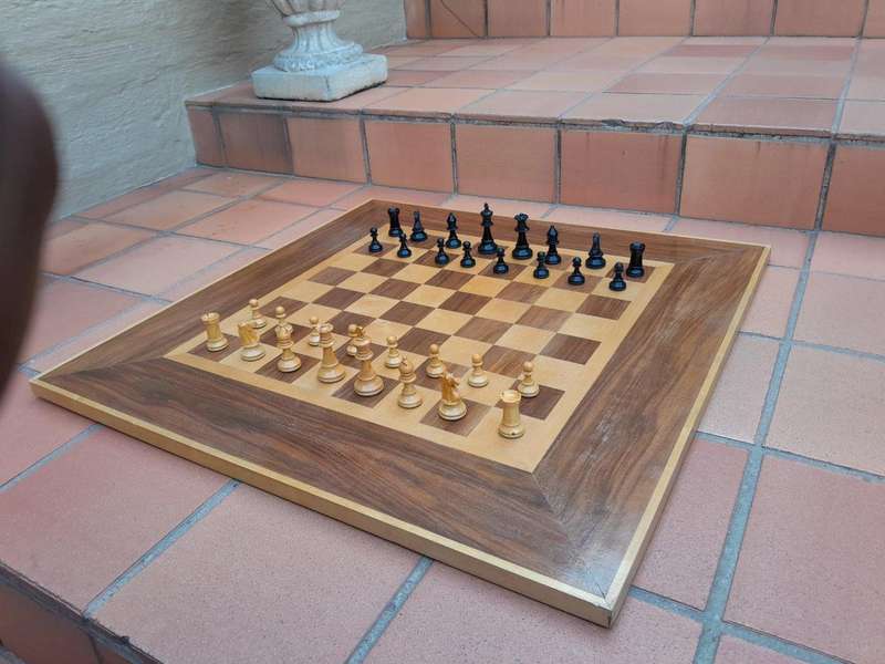 A Wooden Chess Set Comprising Chess Pieces And A Chess Board