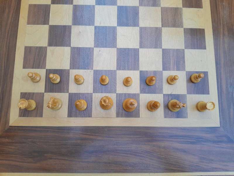 A Wooden Chess Set Comprising Chess Pieces And A Chess Board