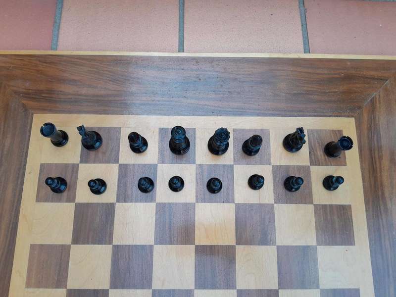 A Wooden Chess Set Comprising Chess Pieces And A Chess Board