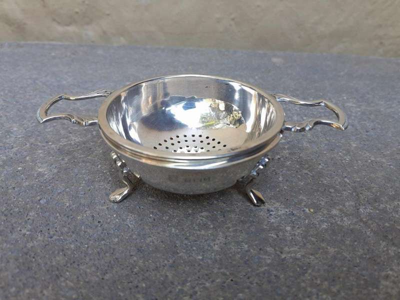 An English Elizabeth II Circa 1956 Georgian-style  Silver Tea Strainer  on Feet  Dimensions: ...