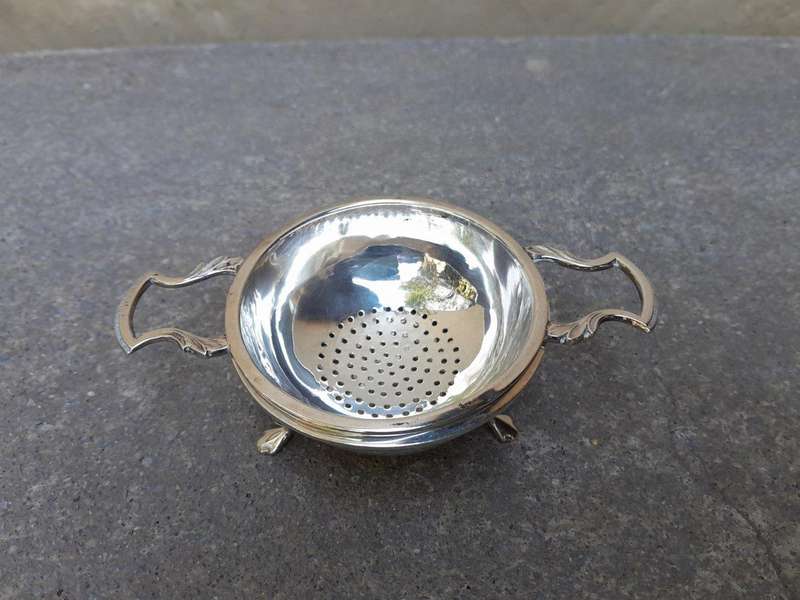 An English Elizabeth II Circa 1956 Georgian-style  Silver Tea Strainer  on Feet  Dimensions: ...