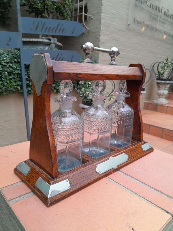 An English Oak Tantalus with 3 Glass Decanters & Metal Hardware