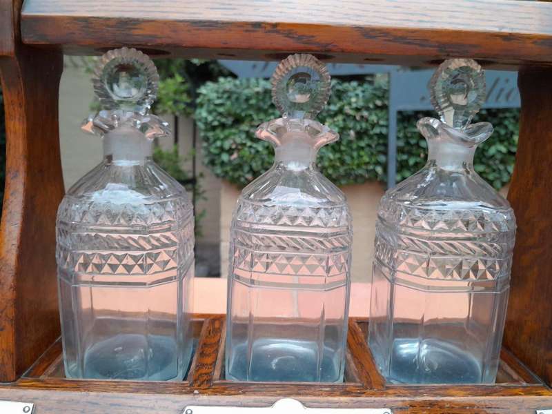 An English Oak Tantalus with 3 Glass Decanters & Metal Hardware