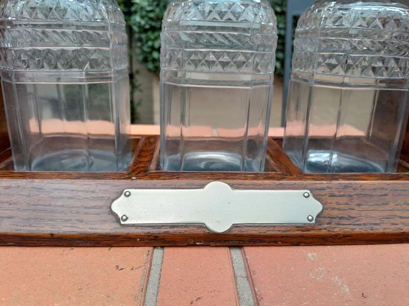 An English Oak Tantalus with 3 Glass Decanters & Metal Hardware
