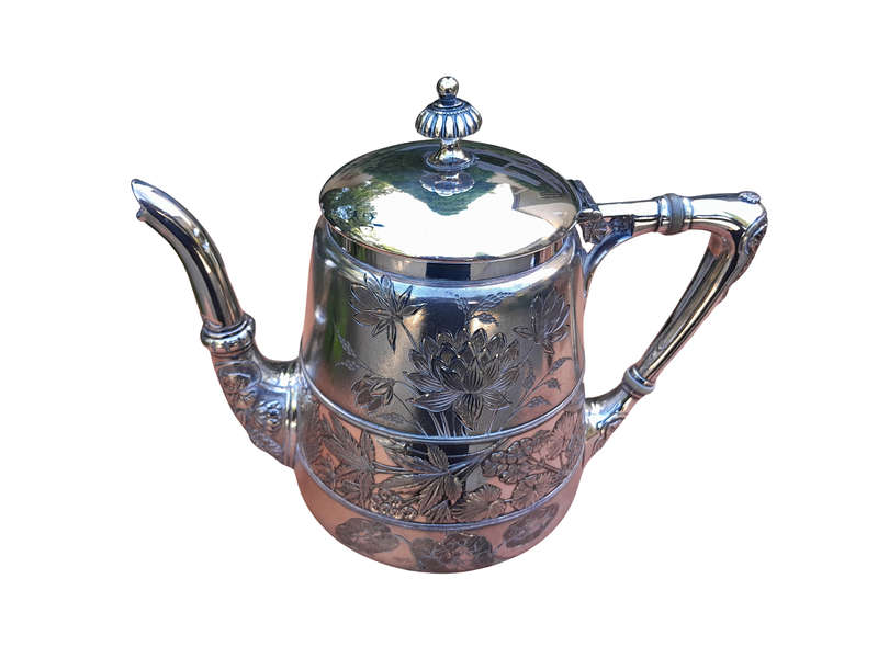 A Silver-Plated Tea Pot With Floral Designs