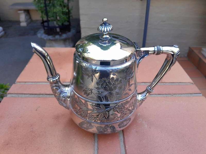 A Silver-Plated Tea Pot With Floral Designs