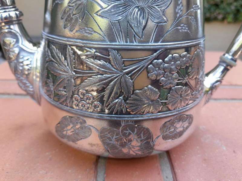 A Silver-Plated Tea Pot With Floral Designs