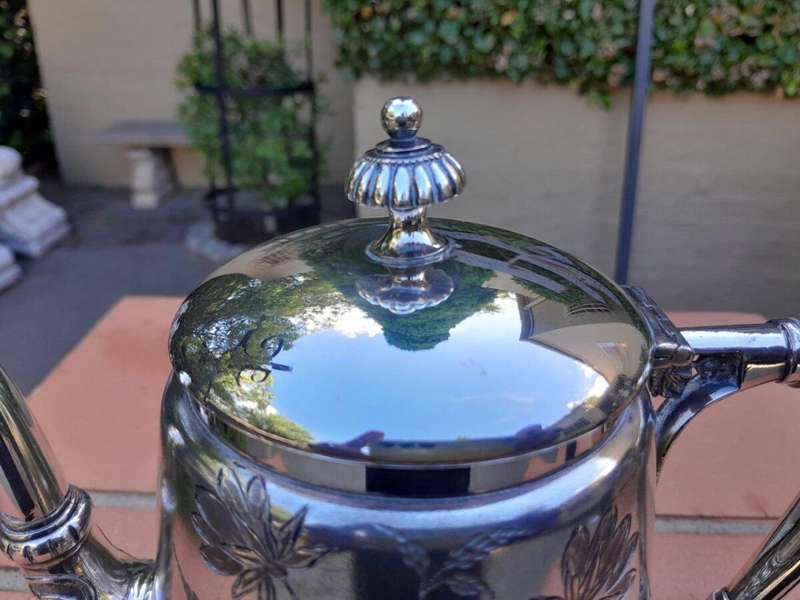 A Silver-Plated Tea Pot With Floral Designs