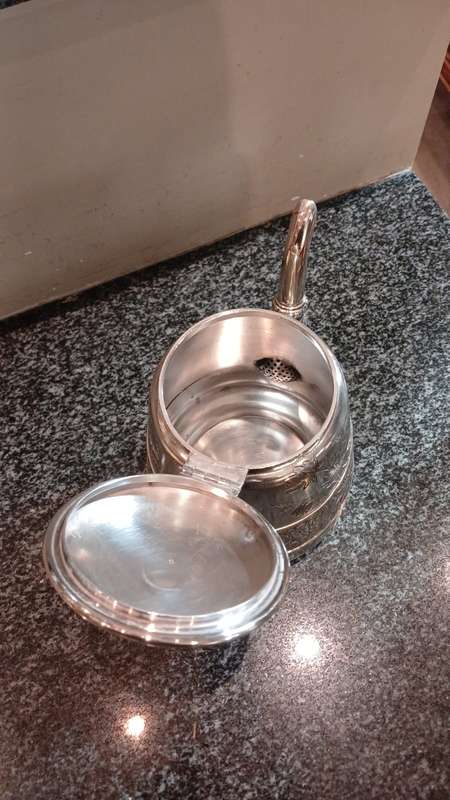 A Silver-Plated Tea Pot With Floral Designs