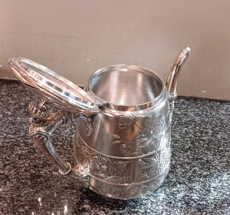 A Silver-Plated Tea Pot With Floral Designs