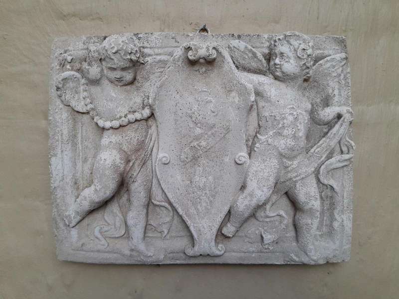 A Concrete Relief Plaque Sculpture With Putti (Cherubs) Holding A Crest