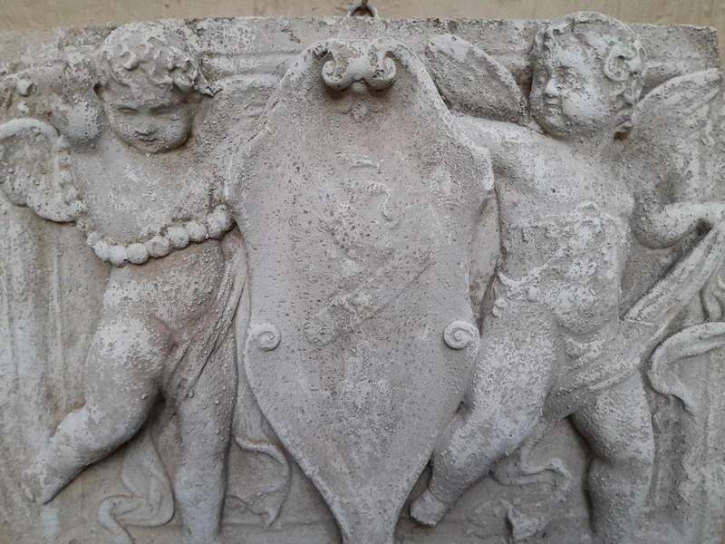 A Concrete Relief Plaque Sculpture With Putti (Cherubs) Holding A Crest