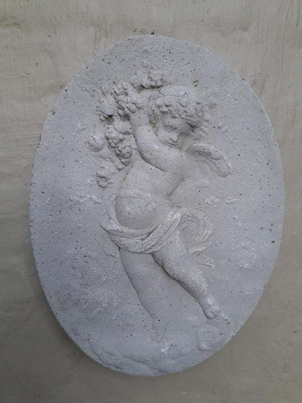 A Concrete Relief Oval Sculpture Of An Ornate Cherub Plaque