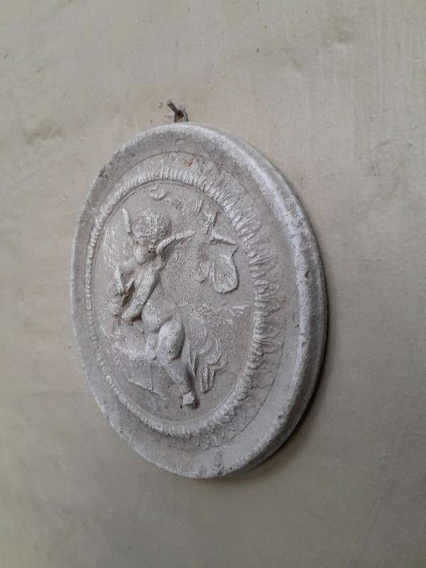 A Concrete Relief Round Sculpture Of An Ornate Cherub Plaque