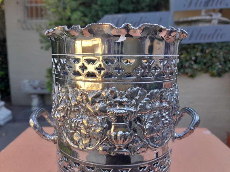 A Silver-Plate Wine Bottle Holder With Two Handles