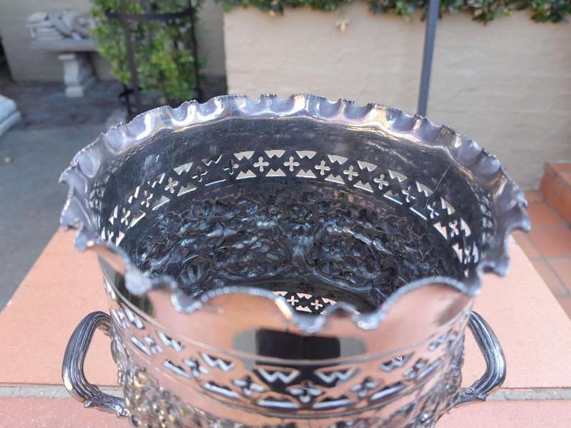 A Silver-Plate Wine Bottle Holder With Two Handles