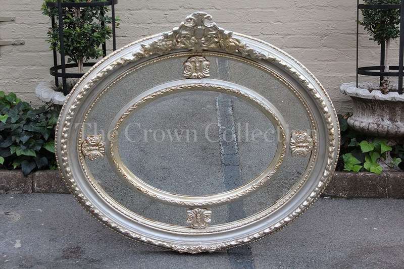Ornate oval silver gilded mirror with crown
